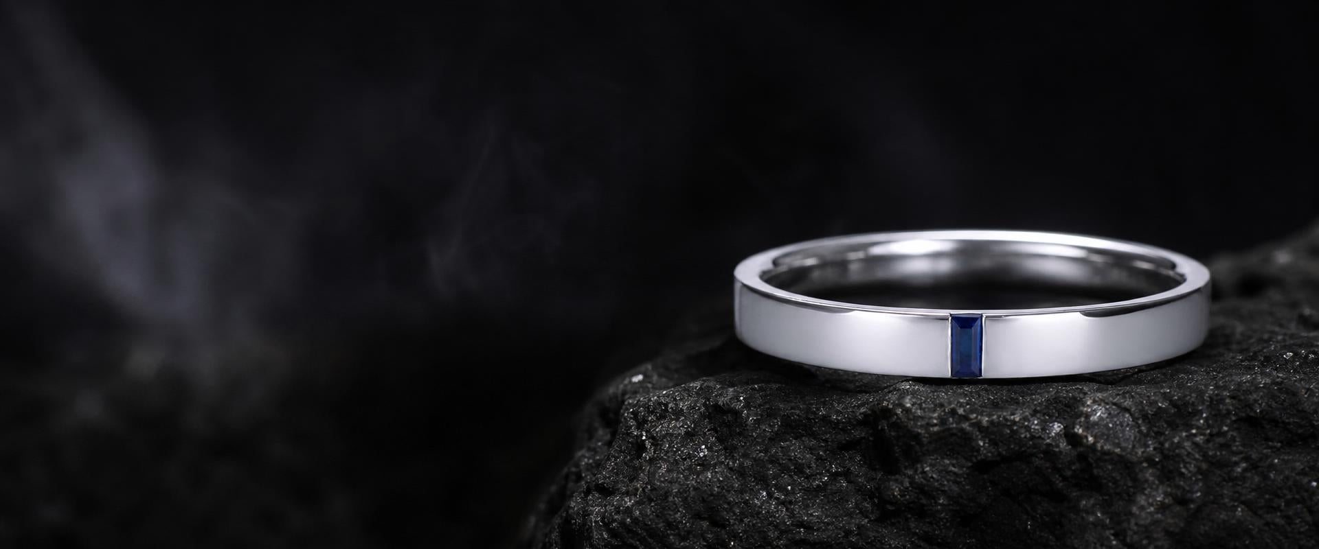 Fine jewellery platinum wedding ring with blue sapphire inlay on stone