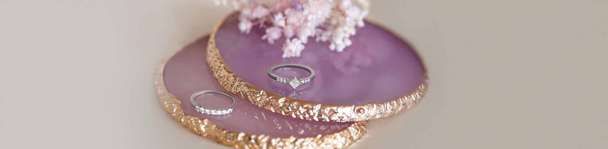 Gold rings with diamonds on purple amethyst geode, wedding ring set with gemstones and fine ring