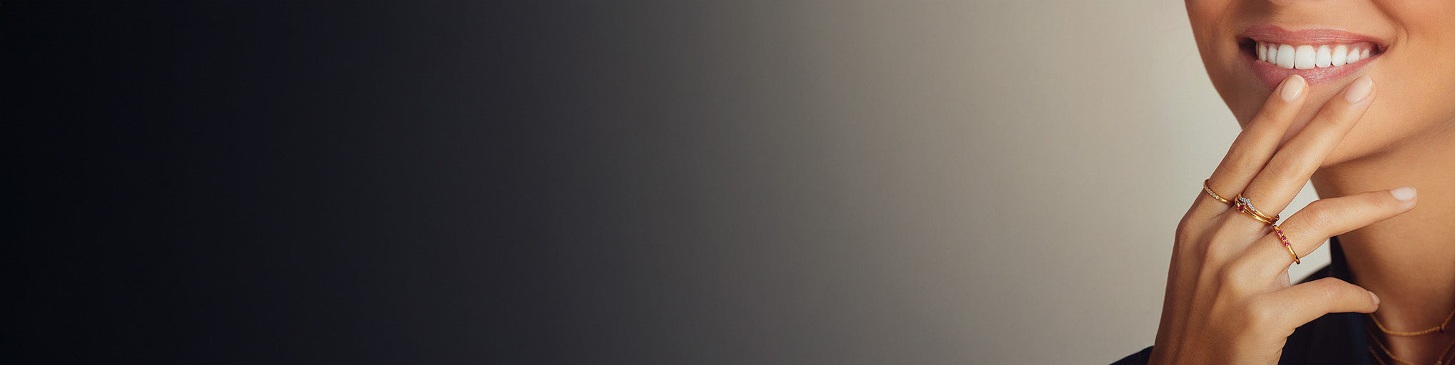 Ruby rings yellow gold 18K worn by smiling woman, fine jewellery with brilliant red gemstones