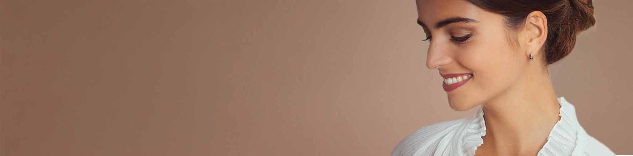 Elegant silver earrings worn by smiling woman, modern fine jewellery refined and elegant