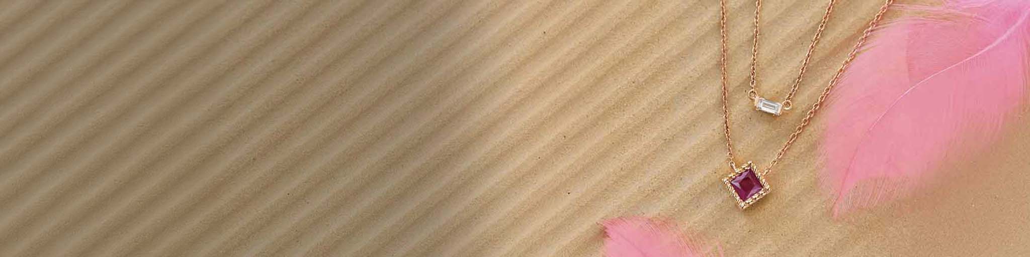 18K rose gold necklaces with diamond and coloured gemstone pendants on beige rose background