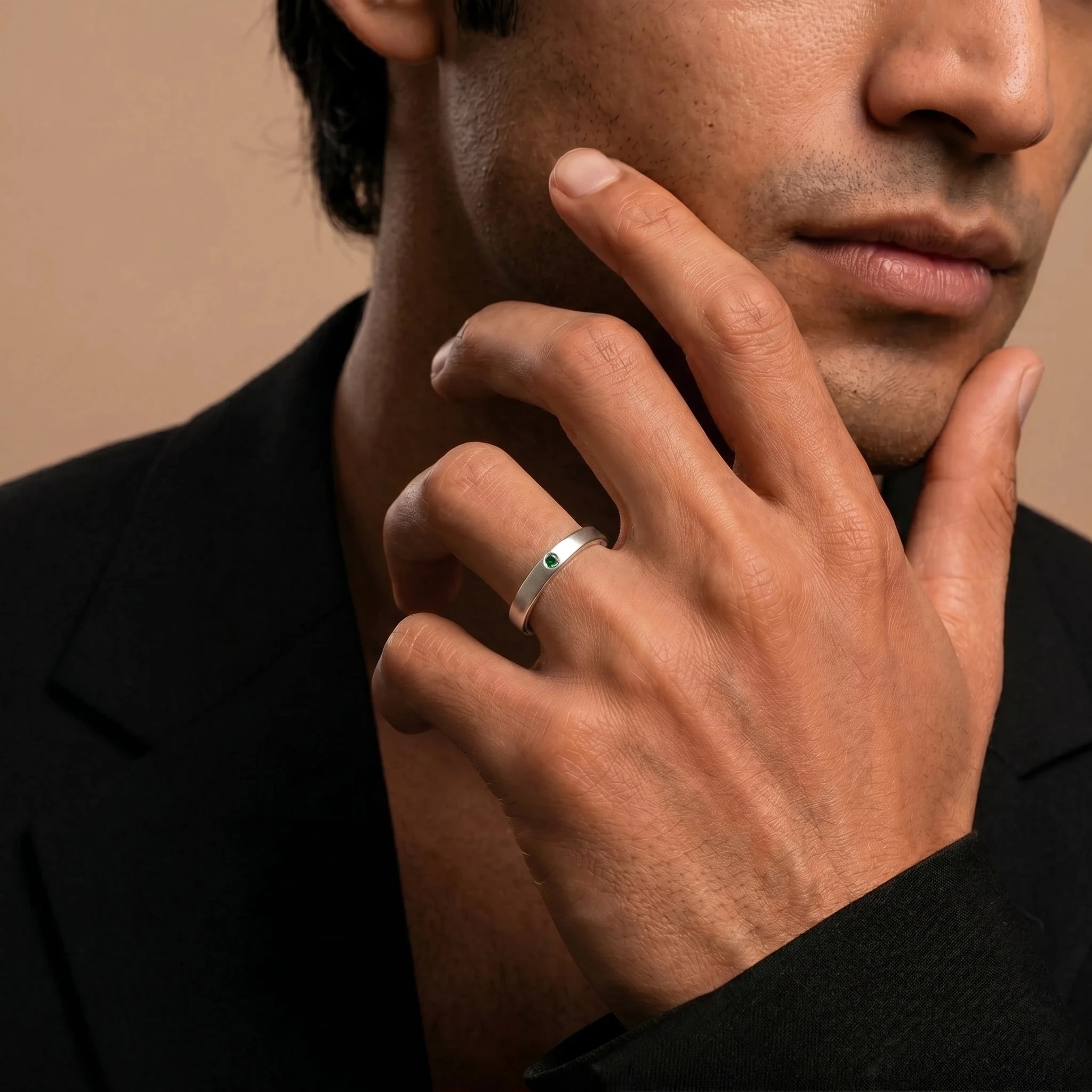 Dhruva emerald band in white gold worn by a man, brushed band