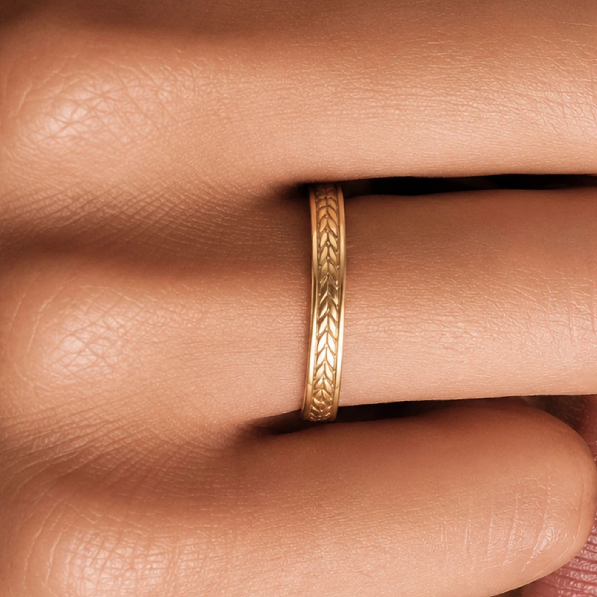 Kléos yellow gold wedding ring worn on the finger, engraving detail