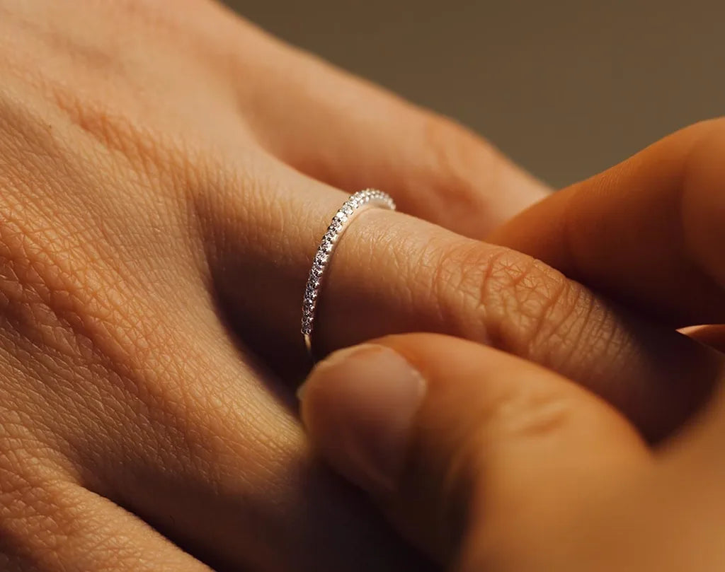 A fine diamond pavé wedding ring in 18ct white gold worn on the finger, a symbol of commitment by Mayuri