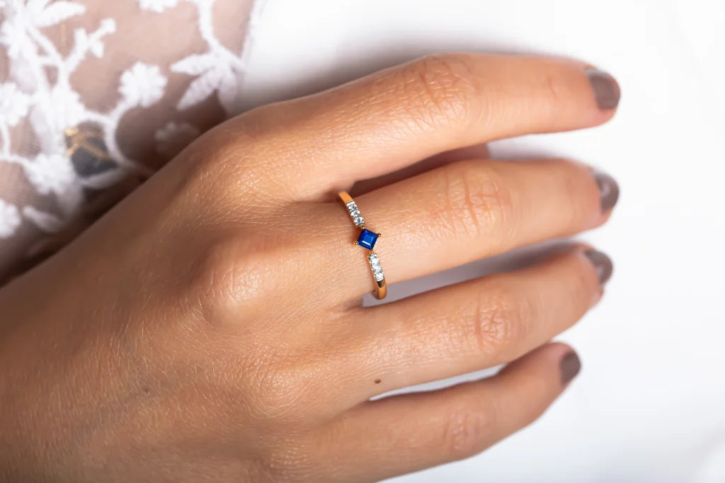 The Kali ring in 18ct gold, set with a princess cut Sapphire and Diamonds, worn on the hand