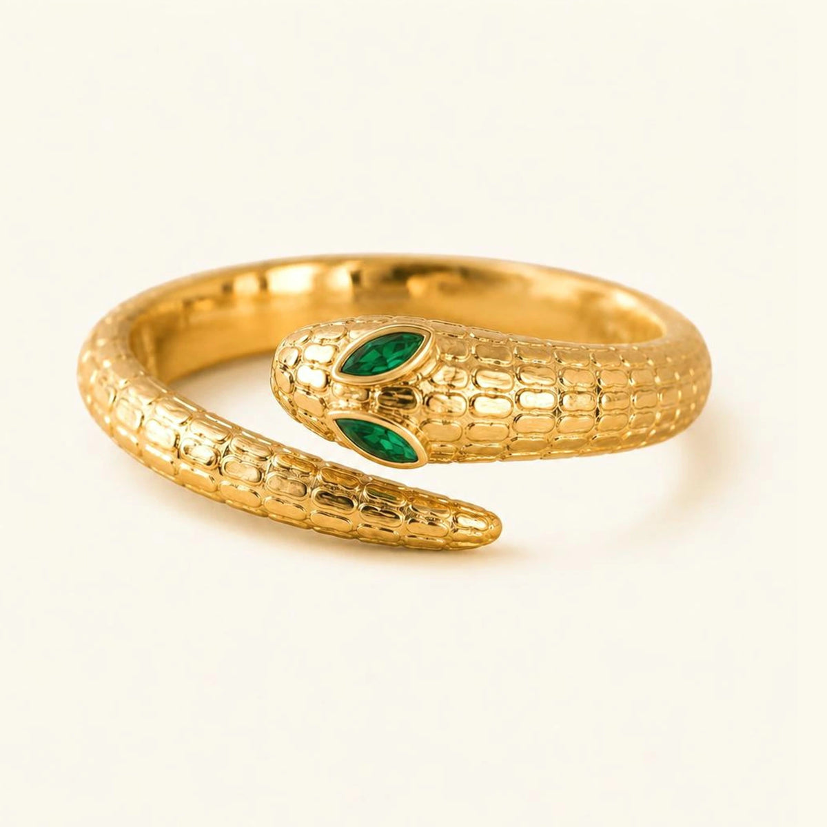 Méhen snake ring in 18K yellow gold, coiled scaled body and two marquise emeralds for the eyes
