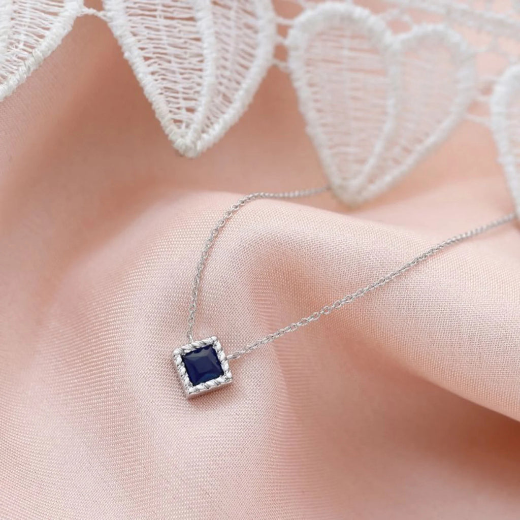 A white gold and Sapphire necklace on cool-undertoned skin, a luminous pairing
