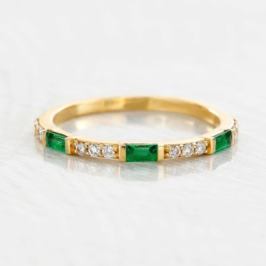 A yellow gold and Emerald ring on warm-undertoned skin, illustrating a natural harmony