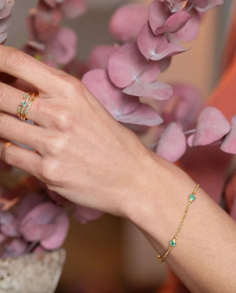 Dhanya bracelet in emerald and yellow gold worn on the wrist, a maid of honour gift idea