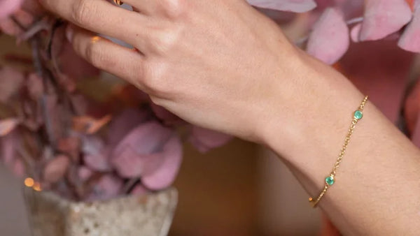 Dhanya bracelet in emerald and yellow gold worn on the wrist, a maid of honour gift idea