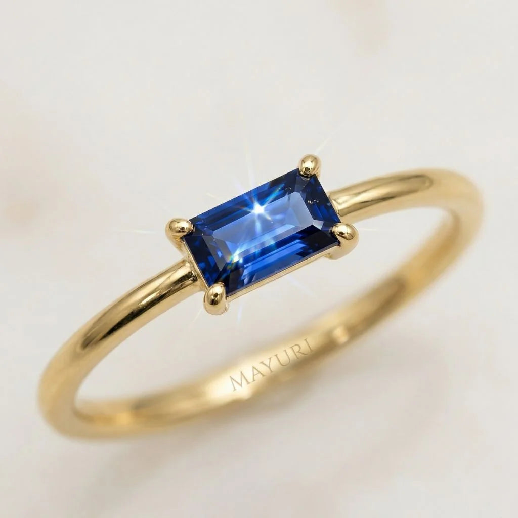 Close-up of a Mayuri 18ct Yellow Gold ring set with a brilliant blue baguette Sapphire