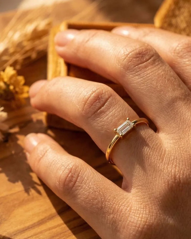 Bague solitaire diamant taille émeraude en or jaune 18 carats portée au doigt