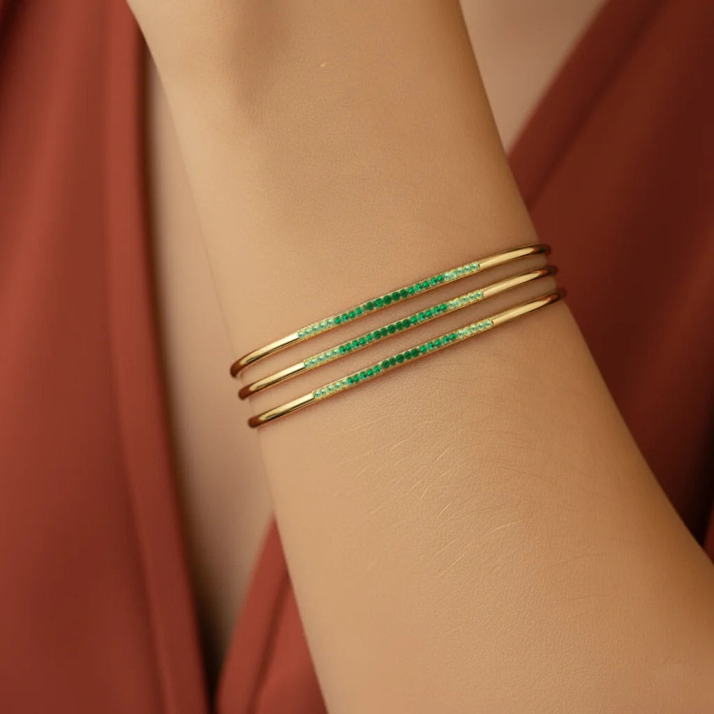 Mayuri Tarang Canopée bangles in 18K yellow gold with a green tsavorite and Emerald gradient
