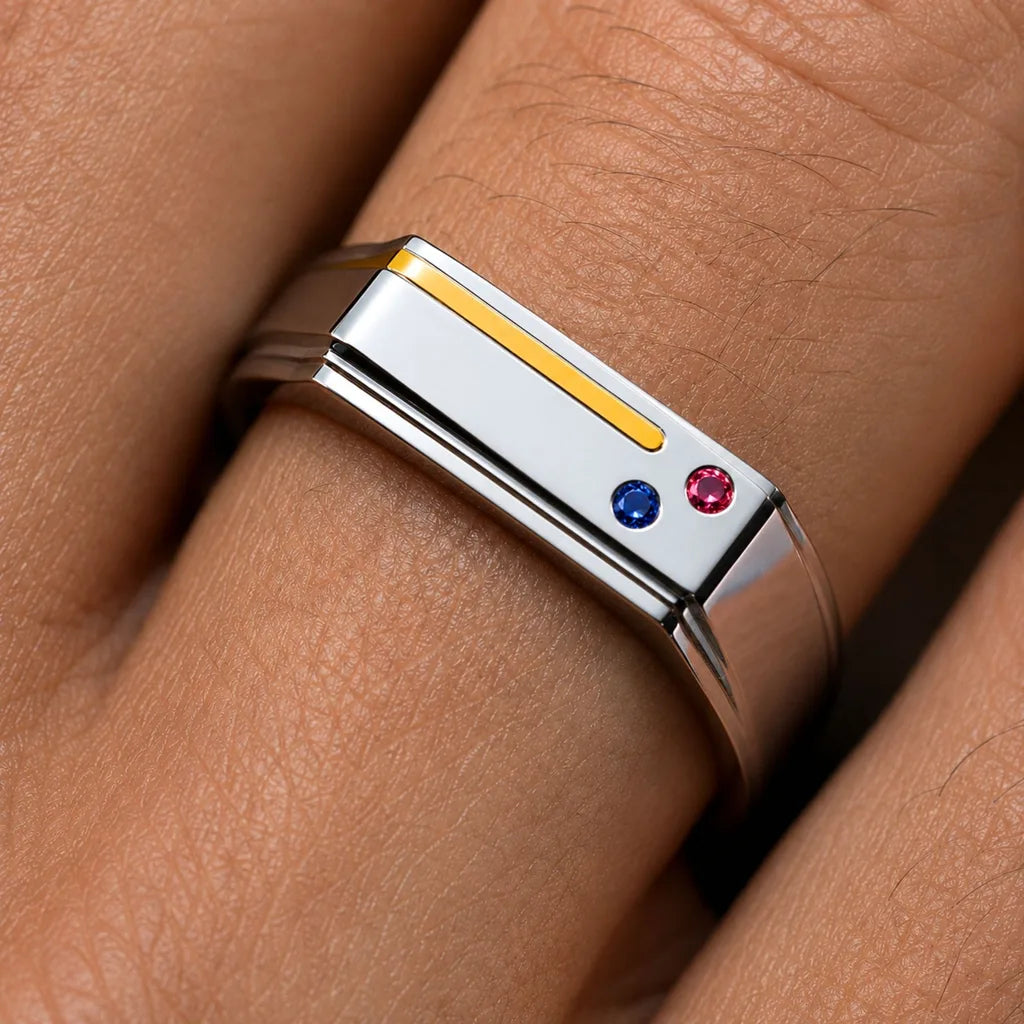 The Essence de Bandor ring in platinum and 18ct yellow gold, with an inlaid gold thread and flush-set Ruby and Sapphire: a two-metal piece receives a hallmark for each metal