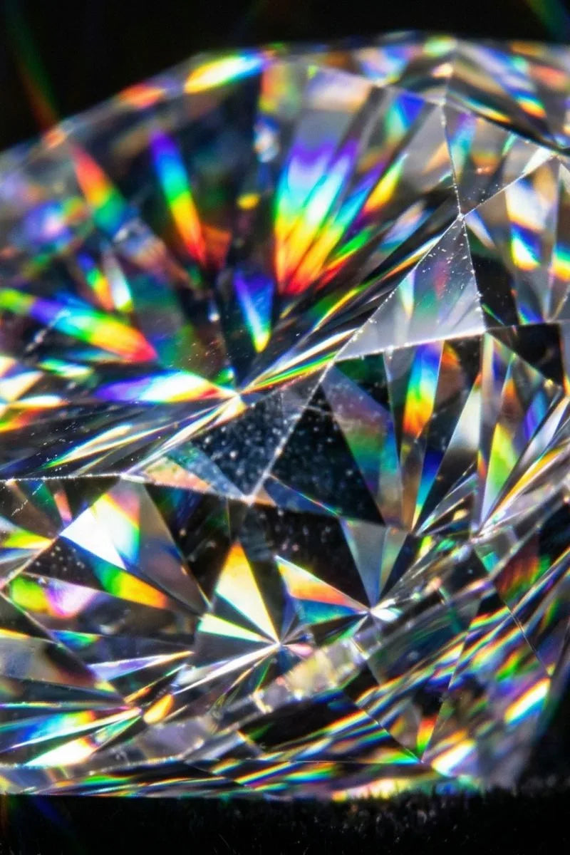 Macro des facettes d'un diamant montrant la dispersion de la lumière et les feux prismatiques